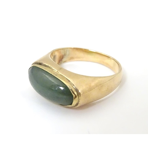 530 - A 14ct gold ring set with jade cabochon. Ring size approx. P 1/2