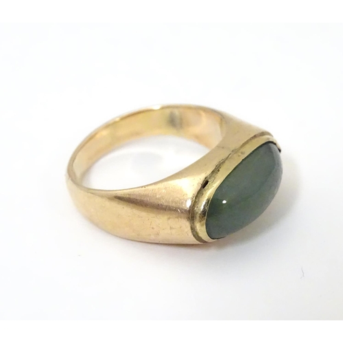 530 - A 14ct gold ring set with jade cabochon. Ring size approx. P 1/2