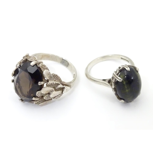 533 - Two silver rings, one set with cats eye cabochon ( ring size approx K) , the other smoky quartz in a... 