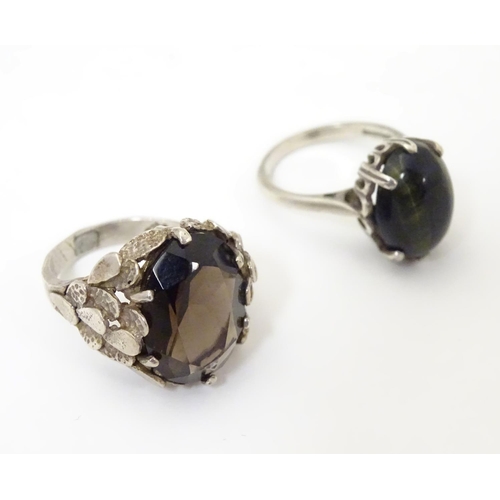 533 - Two silver rings, one set with cats eye cabochon ( ring size approx K) , the other smoky quartz in a... 