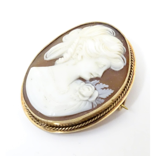 544 - A 20thC shell carved cameo brooch in a 9ct gold mount. 1 1/2