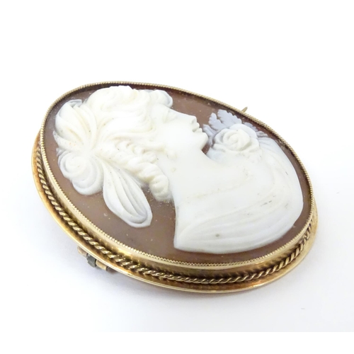 544 - A 20thC shell carved cameo brooch in a 9ct gold mount. 1 1/2