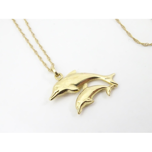 545 - A 9ct double dolphin pendant on a gold chain 16