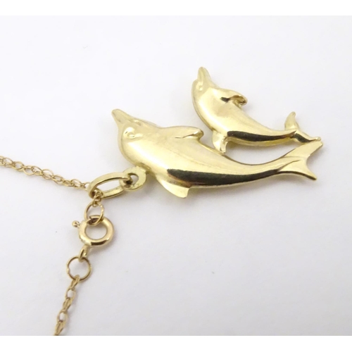 545 - A 9ct double dolphin pendant on a gold chain 16