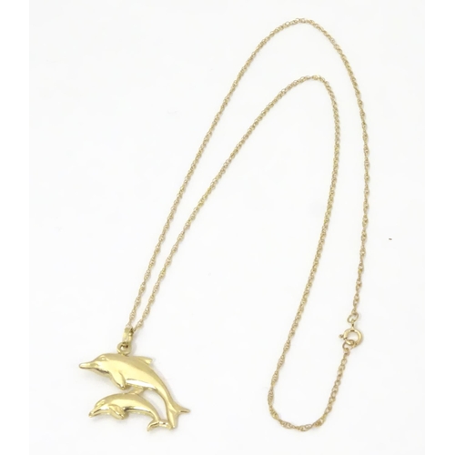 545 - A 9ct double dolphin pendant on a gold chain 16