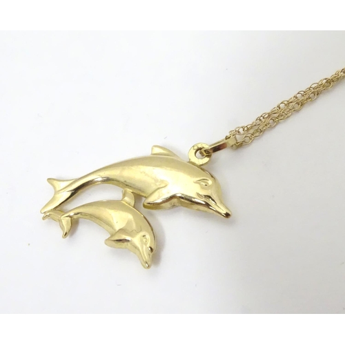 545 - A 9ct double dolphin pendant on a gold chain 16