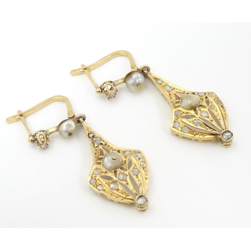 556 - A pair of gold drop earrings set with diamonds and pearls. Approx 1 1/2