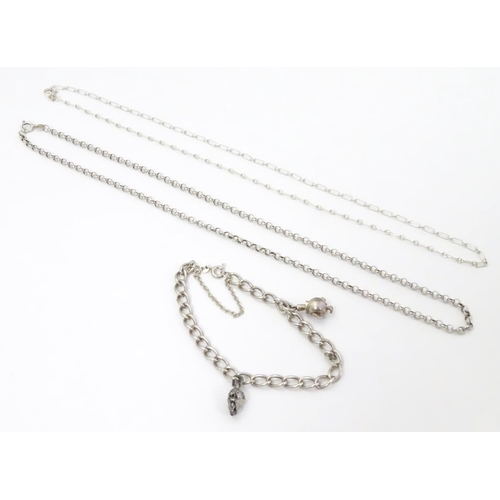 567 - Two silver chain necklaces together with a silver chain bracelet with two charms, one formed as a sk... 