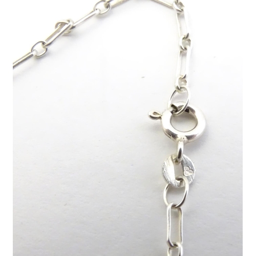 567 - Two silver chain necklaces together with a silver chain bracelet with two charms, one formed as a sk... 