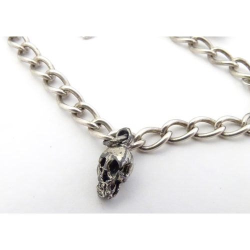 567 - Two silver chain necklaces together with a silver chain bracelet with two charms, one formed as a sk... 