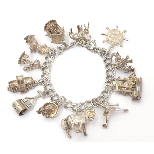 568 - A charm bracelet with 12 various silver and silver plate charms