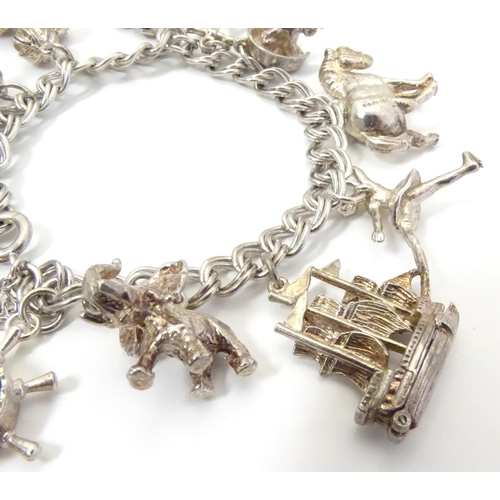 568 - A charm bracelet with 12 various silver and silver plate charms