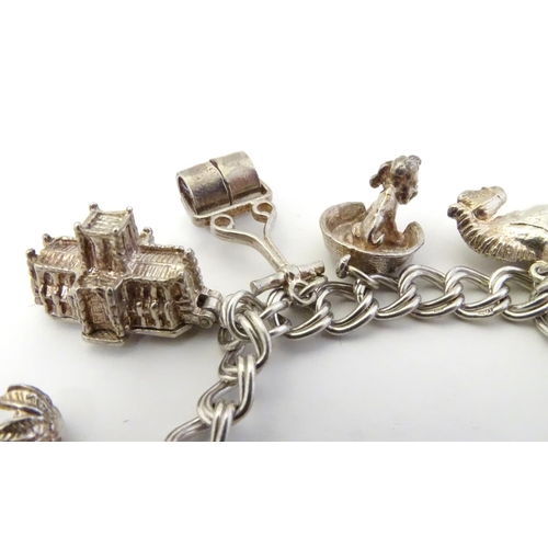 568 - A charm bracelet with 12 various silver and silver plate charms