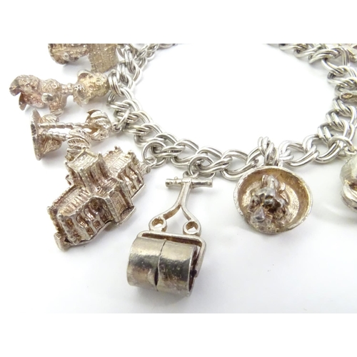 568 - A charm bracelet with 12 various silver and silver plate charms