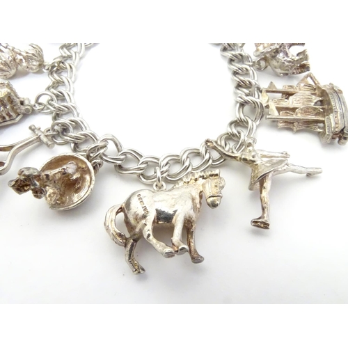 568 - A charm bracelet with 12 various silver and silver plate charms