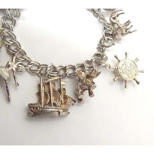 568 - A charm bracelet with 12 various silver and silver plate charms