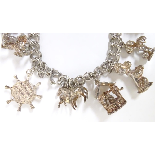 568 - A charm bracelet with 12 various silver and silver plate charms