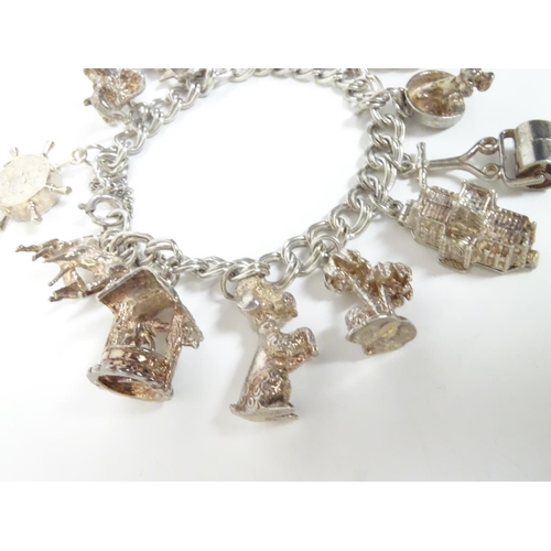 568 - A charm bracelet with 12 various silver and silver plate charms