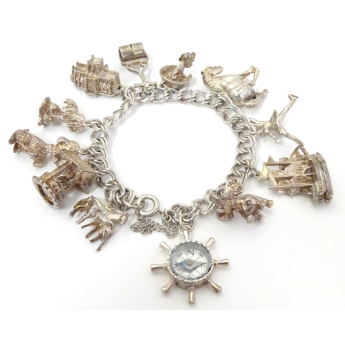 568 - A charm bracelet with 12 various silver and silver plate charms