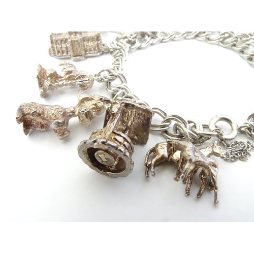 568 - A charm bracelet with 12 various silver and silver plate charms