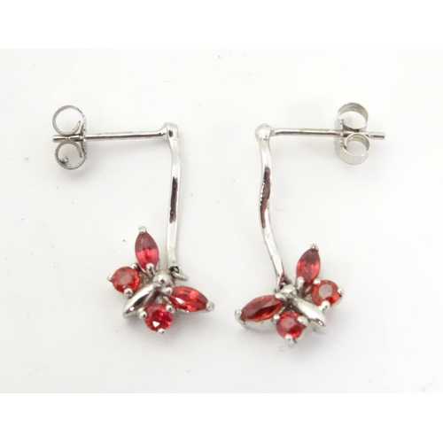 583 - 9ct white gold drop earrings with butterfly detail red stones. 3/4