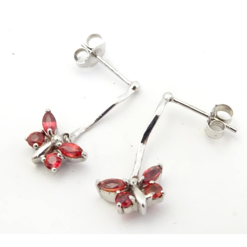 583 - 9ct white gold drop earrings with butterfly detail red stones. 3/4