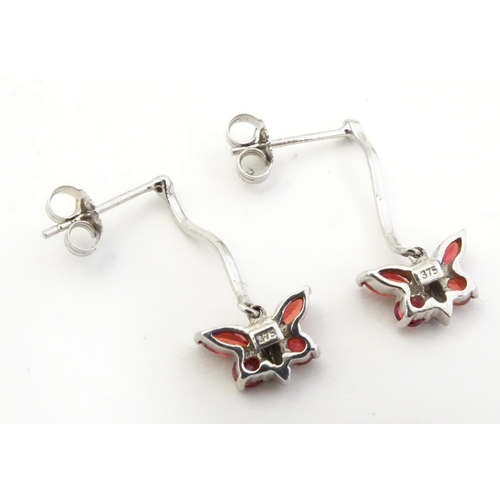 583 - 9ct white gold drop earrings with butterfly detail red stones. 3/4