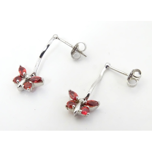 583 - 9ct white gold drop earrings with butterfly detail red stones. 3/4