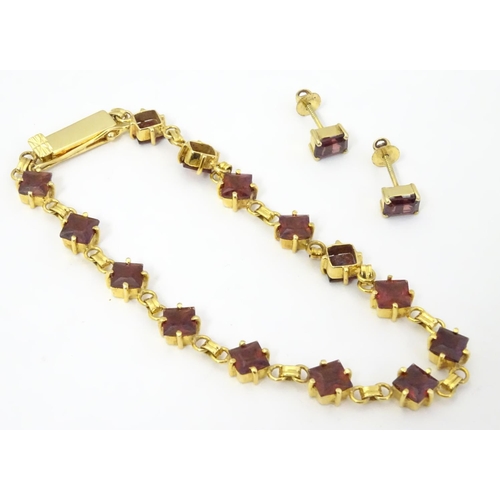 587 - A 14ct gold bracelet set with 14 garnets together with matching stud earrings