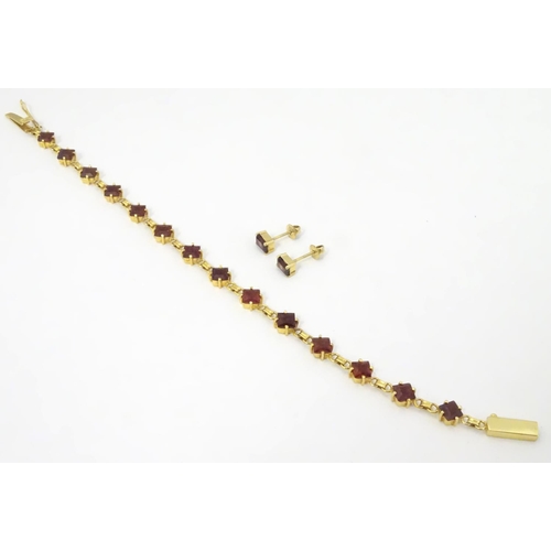 587 - A 14ct gold bracelet set with 14 garnets together with matching stud earrings