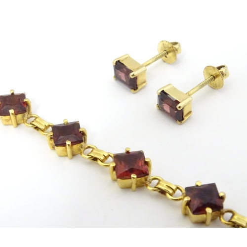 587 - A 14ct gold bracelet set with 14 garnets together with matching stud earrings