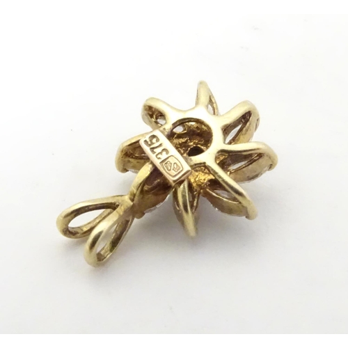 591 - A 9ct gold pendant of flower form set with white stones. 3/4