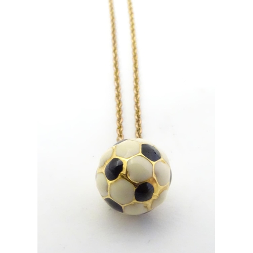 603 - A novelty pendant / charm formed as a football with enamel decoration. on a 9ct gold chain Approx 16... 