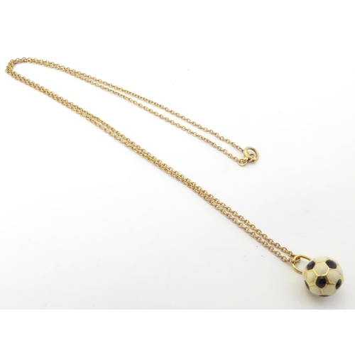 603 - A novelty pendant / charm formed as a football with enamel decoration. on a 9ct gold chain Approx 16... 