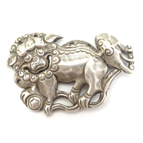 614 - An oriental white metal decorative mount formed as a Chinese lion dog / Shishi. 1 3/4