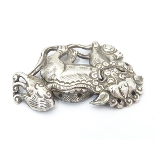 614 - An oriental white metal decorative mount formed as a Chinese lion dog / Shishi. 1 3/4