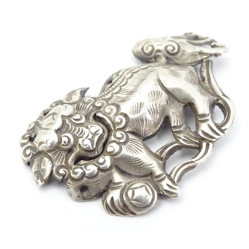 614 - An oriental white metal decorative mount formed as a Chinese lion dog / Shishi. 1 3/4