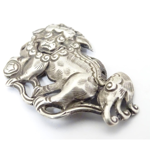 614 - An oriental white metal decorative mount formed as a Chinese lion dog / Shishi. 1 3/4