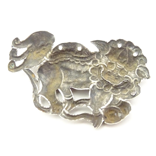 614 - An oriental white metal decorative mount formed as a Chinese lion dog / Shishi. 1 3/4