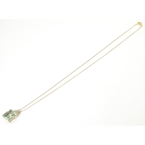 625 - A 9ct gold pendant set with pale green spinel and diamonds on a 16