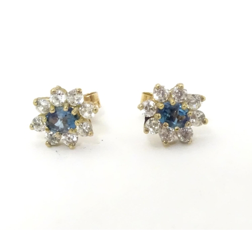 632 - A pair of stud earrings set with green spinel and white stones in a cluster setting. approx. 1/4