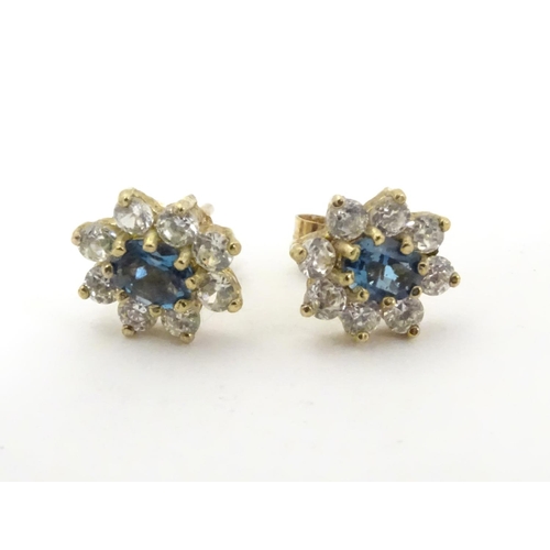 632 - A pair of stud earrings set with green spinel and white stones in a cluster setting. approx. 1/4