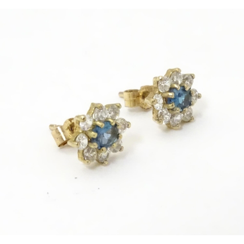 632 - A pair of stud earrings set with green spinel and white stones in a cluster setting. approx. 1/4