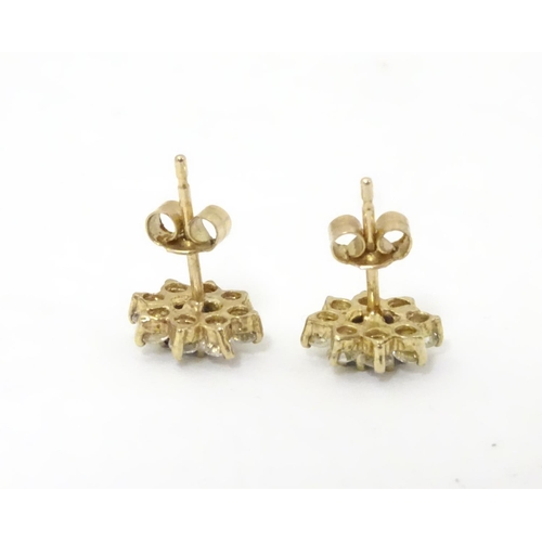 632 - A pair of stud earrings set with green spinel and white stones in a cluster setting. approx. 1/4