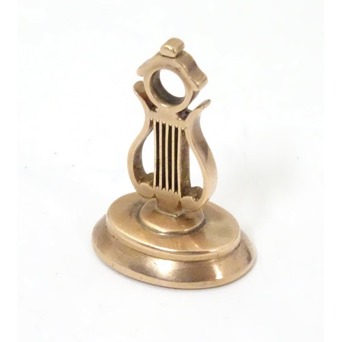 650 - A gold pendant fob seal formed a lyre, 1