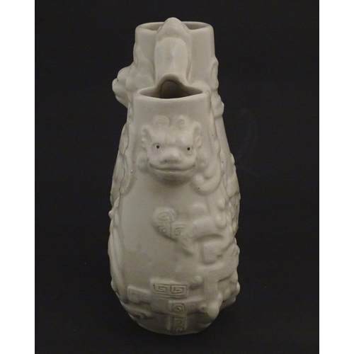 73 - A Chinese blanc de chine double baluster vase decorated in relief with lion dog masks, scrolling fol... 