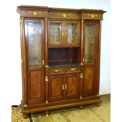 1384 - A large continental mahogany cabinet with a moulded cornice above gilt metal mounts and glazed doors... 