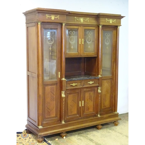 1384 - A large continental mahogany cabinet with a moulded cornice above gilt metal mounts and glazed doors... 