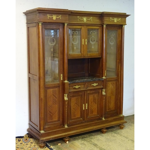 1384 - A large continental mahogany cabinet with a moulded cornice above gilt metal mounts and glazed doors... 