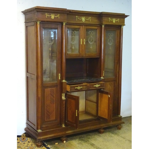 1384 - A large continental mahogany cabinet with a moulded cornice above gilt metal mounts and glazed doors... 